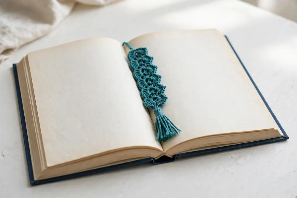 Teal crochet bookmark in an open book